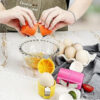 Hand using the Egg Shell Opener to open a raw egg over a bowl