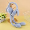 Light blue fluffy bunny ear muffs hanging on a wooden display stand